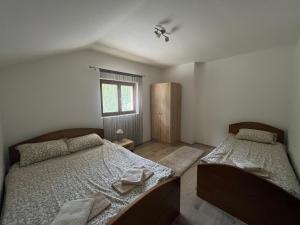una camera da letto con due letti e una finestra di Mokra Gora Central Apartments a Mokra Gora