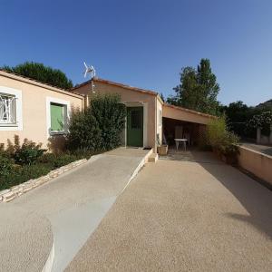 una casa con una porta verde e un vialetto di Maison indépendante a Salinelles