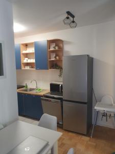 cocina con nevera, mesa y sillas en Studio Apartment Svjetlana, en Biograd na Moru