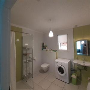 a bathroom with a toilet and a washing machine at Maison indépendante in Salinelles