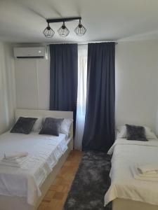 2 camas en una habitación con cortinas azules en Studio Apartment Svjetlana, en Biograd na Moru