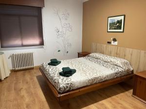 Hotel relojero في لا غودينيا: غرفة نوم عليها سرير وفوط خضراء