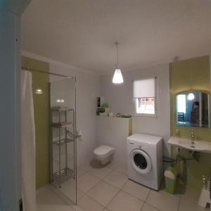 łazienka z toaletą i pralką w obiekcie Maison indépendante w mieście Salinelles