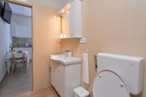 MD Studio apartman في رييكا: حمام مع مرحاض ومغسلة