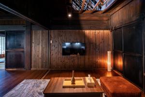 uma sala de estar com uma mesa e uma televisão em LiveGRACE House Lake Saiko 西湖古民家 em Yamanashi