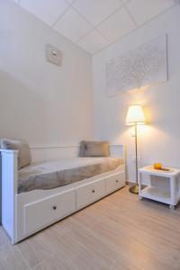 MD Studio apartman في رييكا: غرفة نوم بيضاء فيها سرير ومصباح