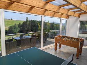a room with a ping pong table on a patio at Eifel-Ferienhaus Landblick in Hürtgenwald