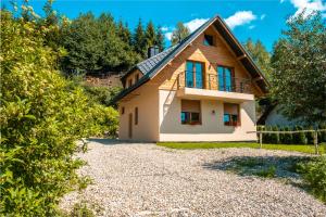 a house on a hill with a gravel driveway at Ostoja Gorce in Nowy Targ