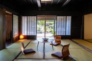 una habitación con sillas y una mesa en una habitación con ventanas en LiveGRACE House Lake Saiko 西湖古民家 en Yamanashi