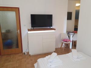 una sala de estar con TV de pantalla plana en un armario blanco en Studio Apartment Svjetlana, en Biograd na Moru