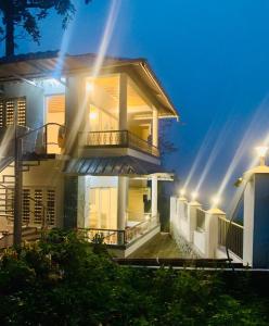 a house with lights on the side of it at The Nirvana Resort Munnar in Munnar