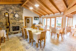 a dining room with tables and chairs and a fireplace at Casa da Ponte de Penas in Melide