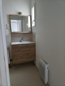 y baño con lavabo y espejo. en La Grimodière Chambre en rez de chaussée, en Ranville