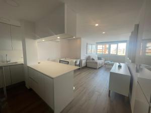uma cozinha e sala de estar com armários brancos e uma mesa em The luxury suite em Alicante