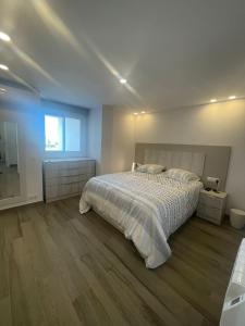 um quarto branco com uma cama e uma janela em The luxury suite em Alicante