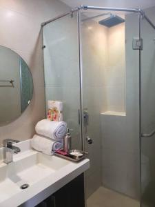 La salle de bains est pourvue d'un lavabo, d'une douche et de serviettes. dans l'établissement Ecusuites Aquamira Salinas 6DResort Ocean View with Balcony, à Salinas