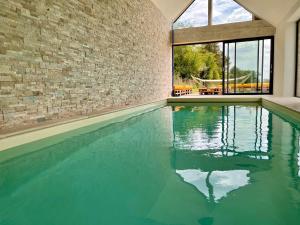 uma piscina interior com uma parede de tijolos em Le QG 28 em Nonvilliers-Grandhoux