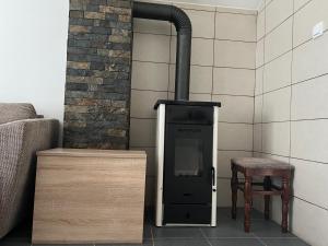 a wood stove with a chair next to a wall at Mokra Gora Central Apartments in Mokra Gora