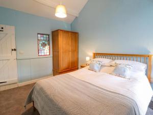 a bedroom with a large bed with white sheets and pillows at Preswylfa in Blaenau-Ffestiniog