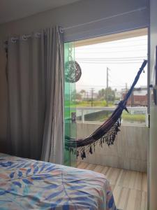 a bed and a hammock in a bedroom with a window at Studio A completo 400m da praia in Porto De Galinhas