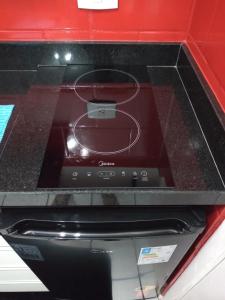 a stove top oven sitting in a red counter top at Sala living na Av da Praia. in Santos