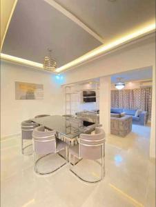 uma sala de estar com uma mesa e cadeiras e um sofá em Appartement Luxe idéalement situé à Dakar em Dakar