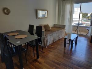 sala de estar con cama, mesa y sillas en Dpto frente shoping en Salta
