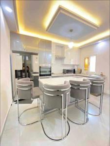 a kitchen with a counter and stools in it at Appartement Luxe idéalement situé à Dakar in Dakar