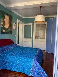 a bedroom with a blue bed with a painting on the wall at Maria Vittoria House in Turin