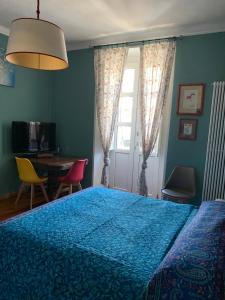 a bedroom with a blue bed with a table and chairs at Maria Vittoria House in Turin