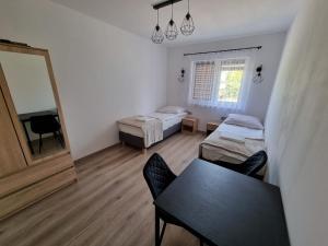 a room with two beds and a table and a mirror at Zacisze na Roztoczu in Horyniec