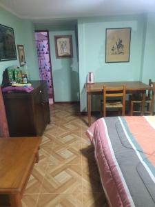 Schlafzimmer mit einem Bett, einem Tisch und einem Schreibtisch in der Unterkunft ROMA in Los Vilos