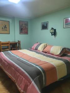 ein Schlafzimmer mit einem großen Bett mit einer bunten Decke in der Unterkunft ROMA in Los Vilos