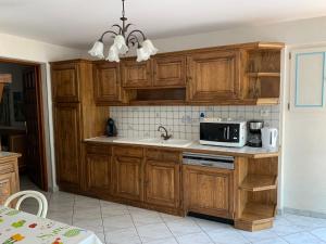 a kitchen with wooden cabinets and a microwave at L'oriere des Bois in Ronchamp