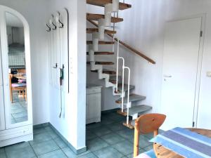 a staircase in a white room with a table at Strandbummelhaus in Warnemünde