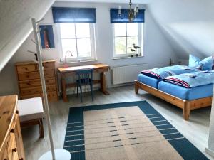 ヴァーネミュンデにあるStrandbummelhausのベッドルーム1室(ベッド1台、デスク、窓付)