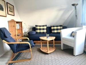 a living room with a blue couch and a chair at Strandbummelhaus in Warnemünde