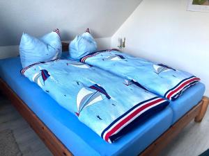 a bed with a blue comforter and pillows at Strandbummelhaus in Warnemünde