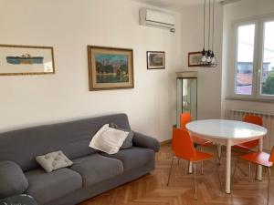 uma sala de estar com um sofá e uma mesa em Casa dei Gelsomini em Trieste