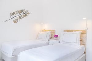 two beds in a white room with white walls at Yasos By The Sea in Çeşme