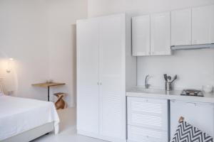 a white kitchen with white cabinets and a sink at Yasos By The Sea in Çeşme