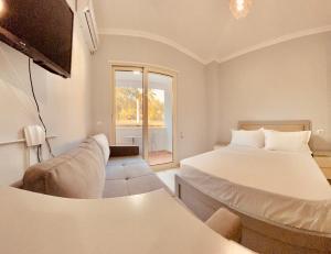a bedroom with two beds and a couch and a window at Flors Apartments in Durrës +88 photos