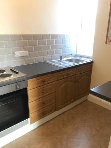 a kitchen with a sink and a stove at Cedar House, formerly Shamrock House in Llandudno