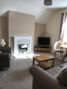 a living room with a couch and a fireplace at Cedar House, formerly Shamrock House in Llandudno