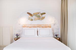 a bedroom with a white bed with two pillows at Yasos By The Sea in Çeşme