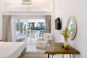 a bedroom with a bed and a chair and a table at Yasos By The Sea in Çeşme