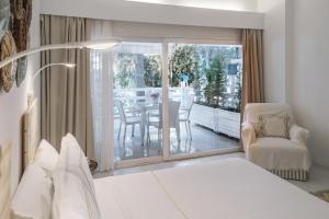 1 dormitorio con 1 cama, mesa y sillas en Yasos Suites, en Cesme