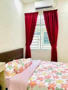 a bedroom with a bed with red curtains and a window at HOMESTAY BANDAR KANGAR (NS FAMILY HOMESTAY) in Kangar