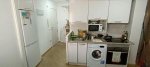a kitchen with a washing machine and a sink at Habitación AP in Madrid