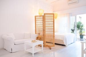 a white living room with a bed and a white couch at Yasos By The Sea in Çeşme